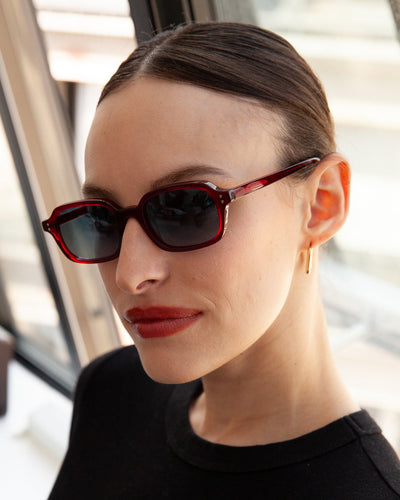 Lunettes de soleil Ren Grenat — monture rectangulaire, portées par une femme